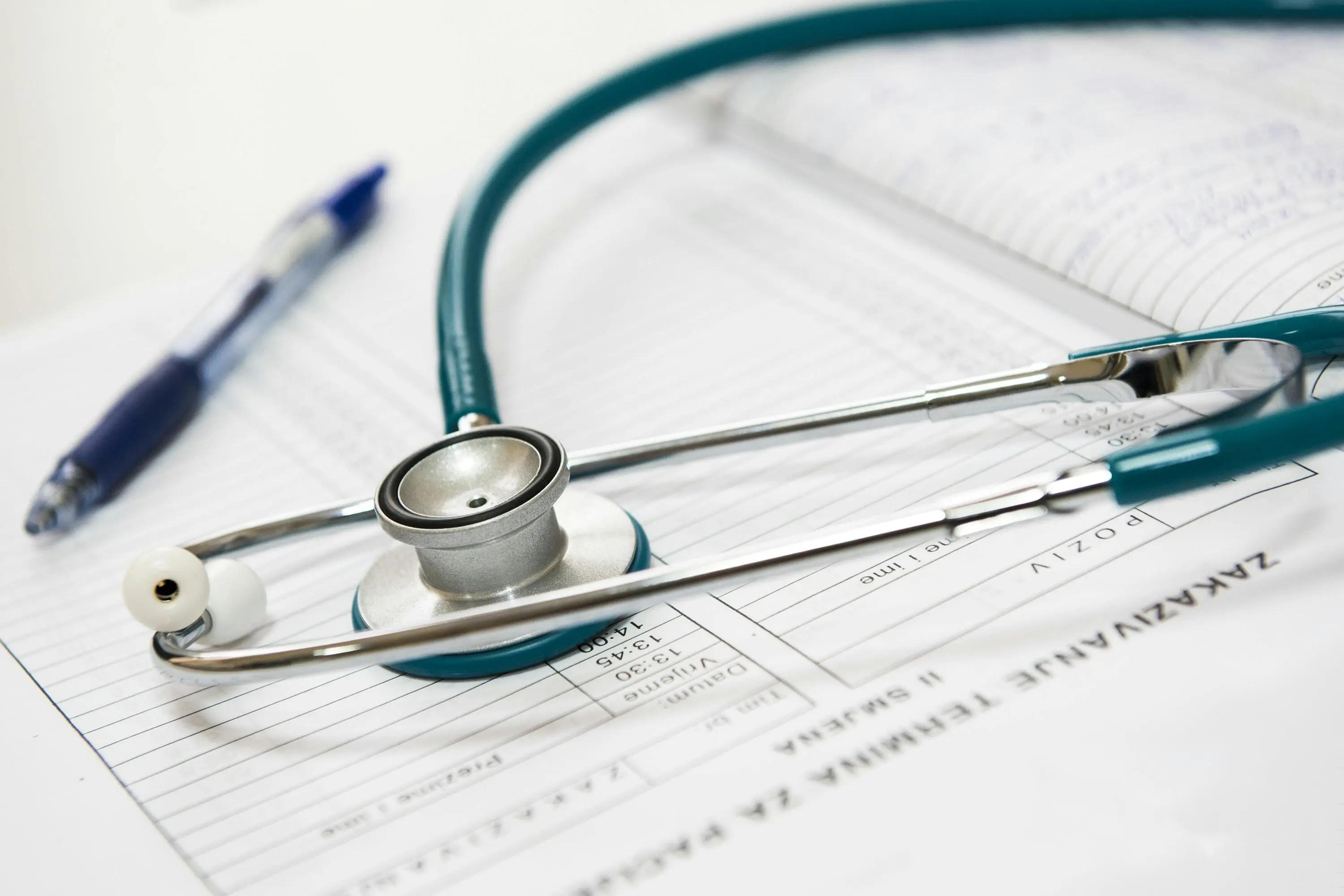 Stethoscope and pen resting on a medical chart, symbolizing health monitoring and planning, essential for learning how to start intermittent fasting with a structured approach to wellness