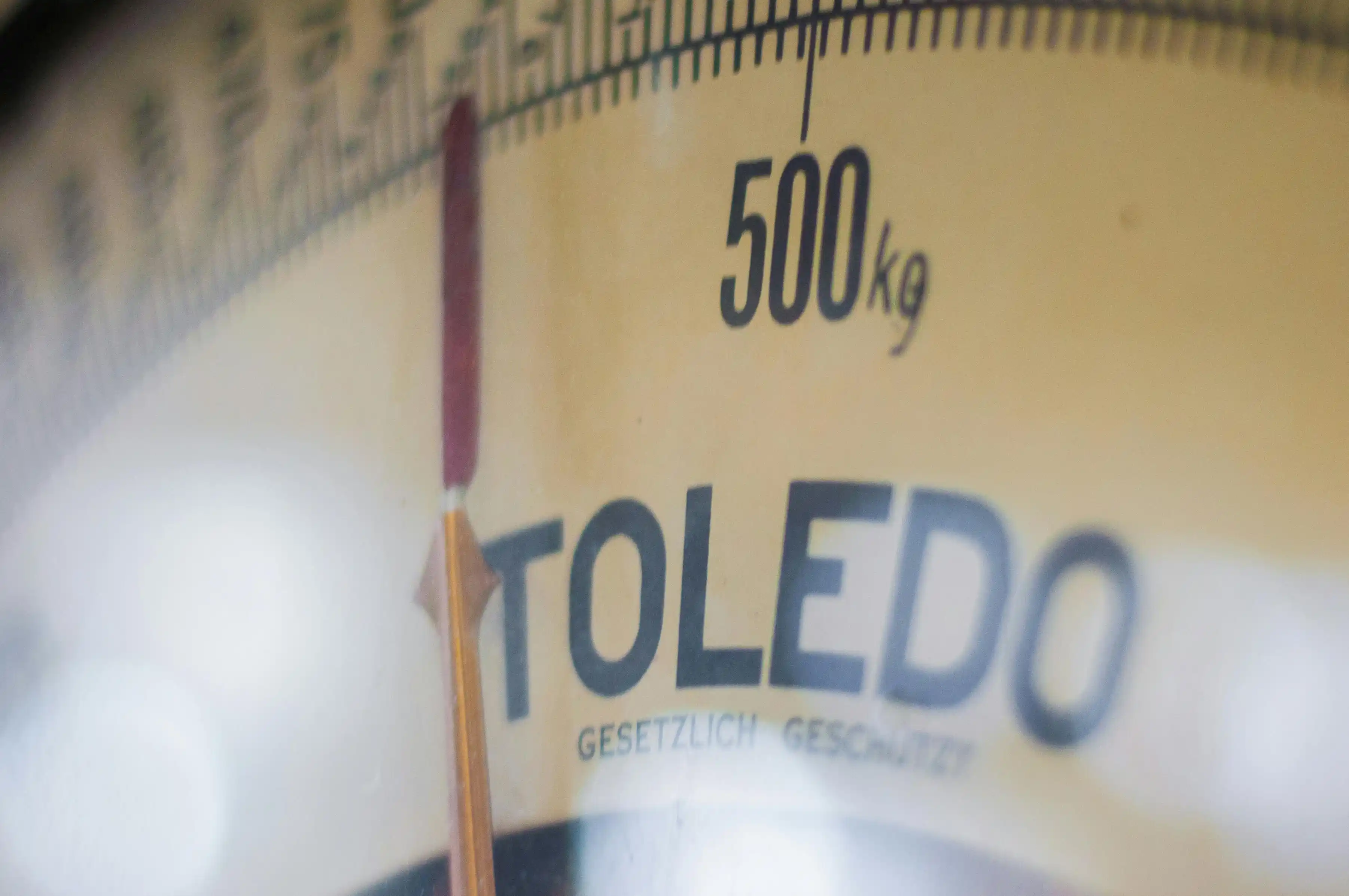 Close-up of a vintage Toledo mechanical weighing scale marked up to 500 kg, with needle pointing near maximum; Concept image for weight tracking in intermittent fasting rules, body weight monitoring, and fasting progress measurement